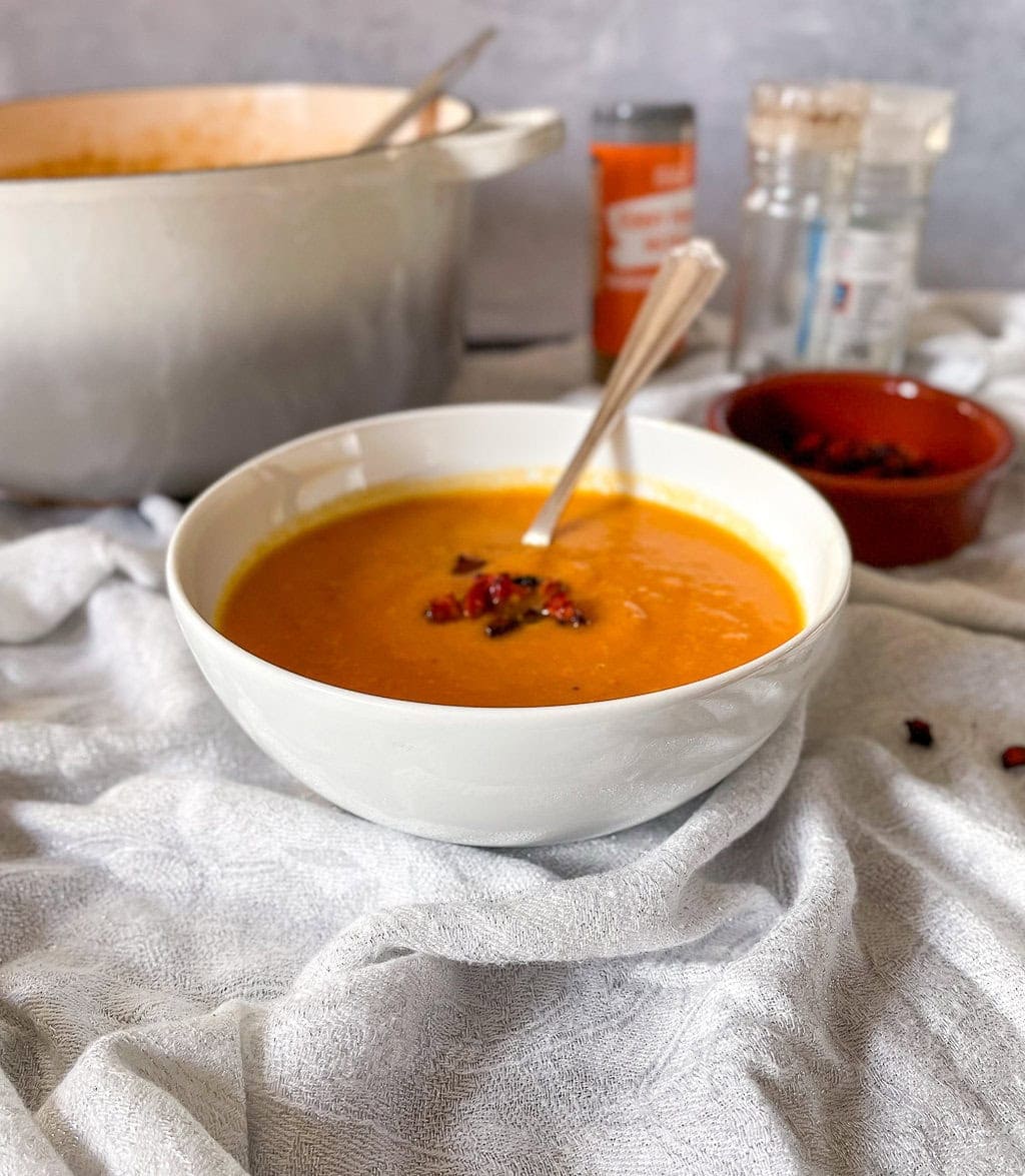 Sweet Potato and Chorizo soup in bowl with cripsy chorizo pieces on top.