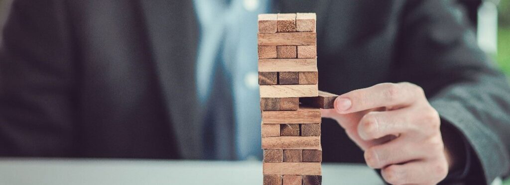 businessman che gioca con mattoncini di legno simbolizzando la stabilità dell'azienda