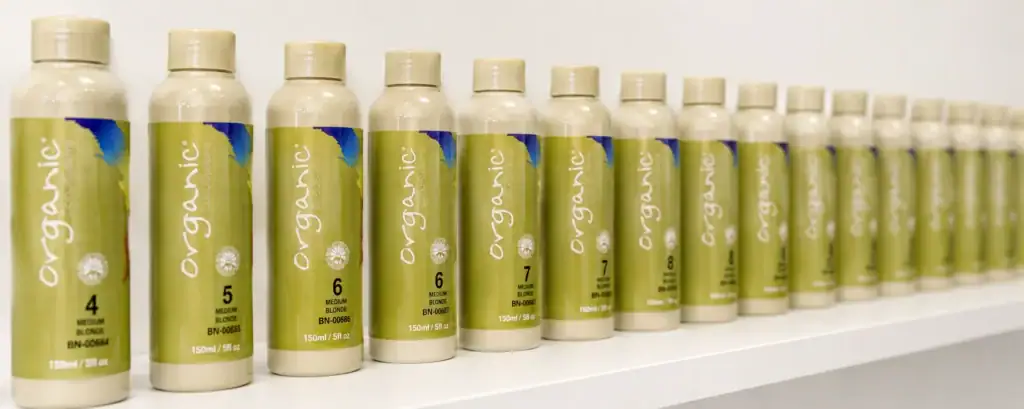 Rij Organic Colour Systems haarkleuringen overzichtelijk gepresenteerd op een wit winkelschap.