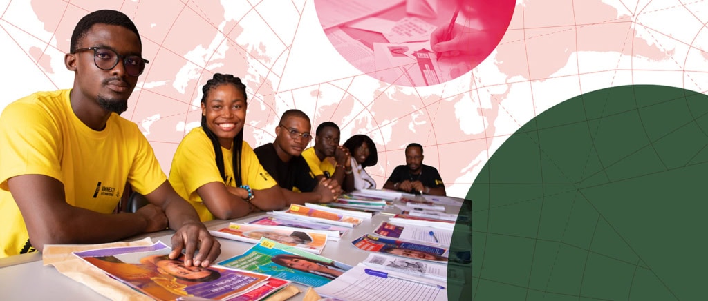 People smiling and writing letters at a Write for Rights event