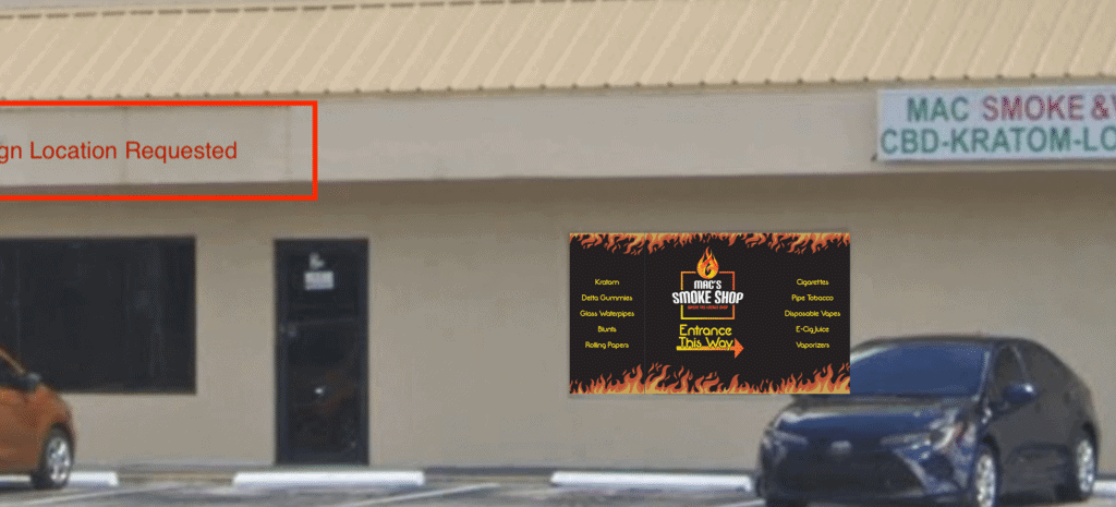 Mac's Smoke Shop window graphic with "Entrance This Way" text. Window sign for local smoke shop.