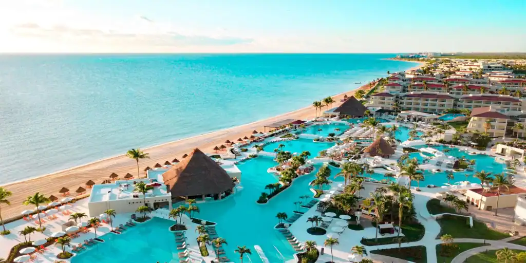 Luxurious oceanfront resort with pools, tropical landscaping, and beach access, perfect for relaxing vacations in Cancun.