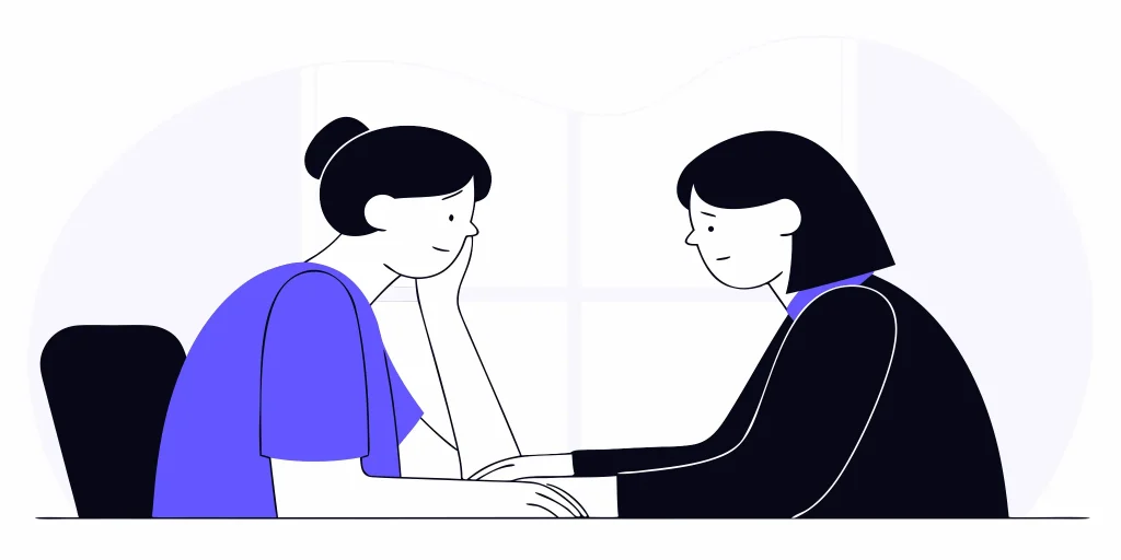 A woman comforts her colleague who is experiencing mental harassment at the workplace.