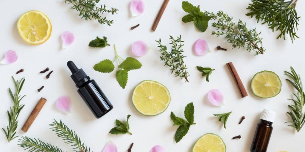 Essential oil bottle among herbs and fruit