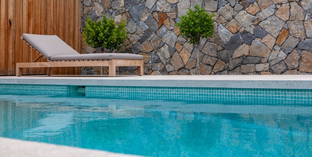 Swimming pool tiling with Tahiti glass mosaic pool tile and natural stone wall claddings
