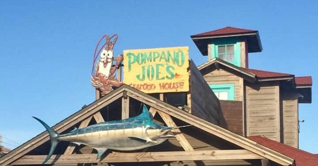 restaurant with giant fish under sign