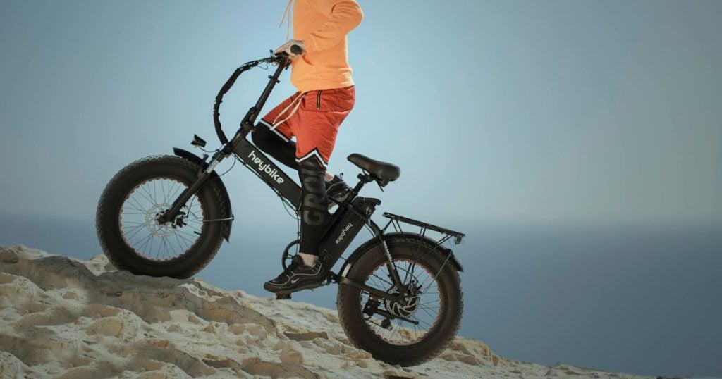 vozač sa terenskim električnim biciklom se vozi uz brdo