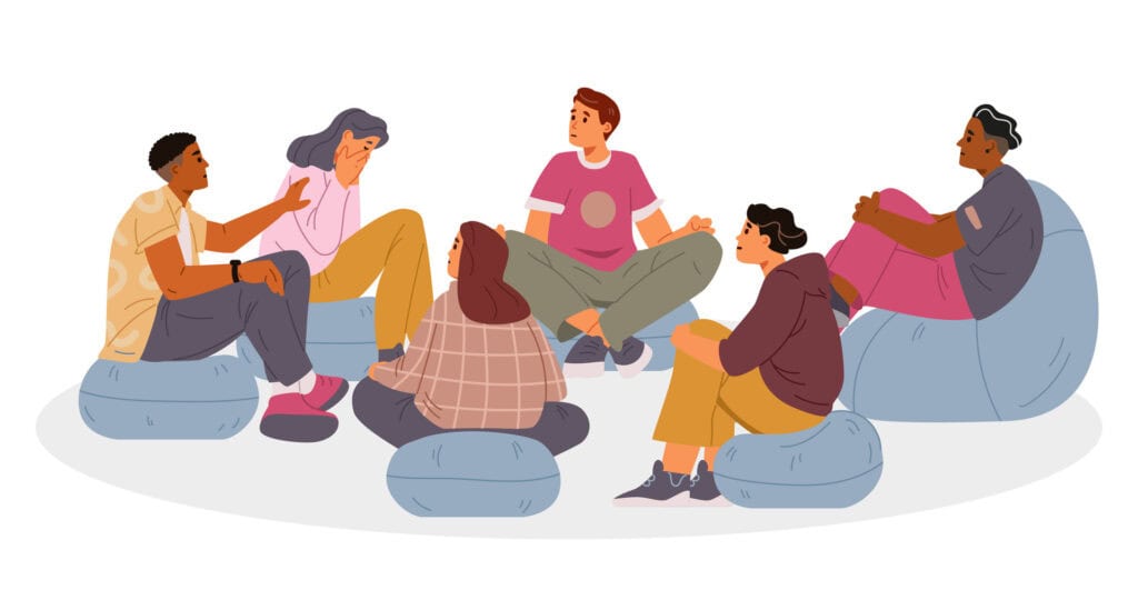 group of racially diverse young people sitting on bean bag chairs in a group therapy setting.