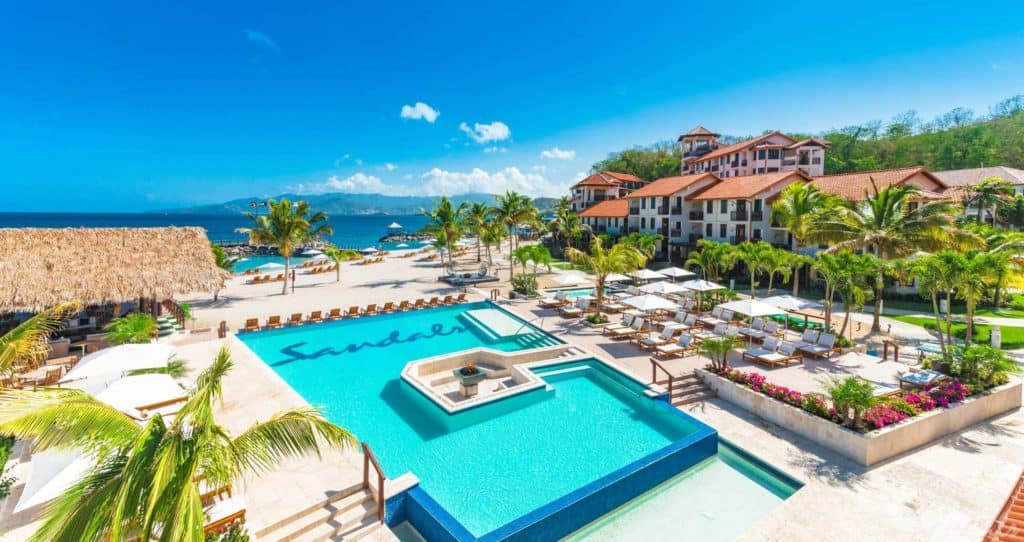 Luxurious beachfront resort infinity pool with ocean views and tropical landscaping.