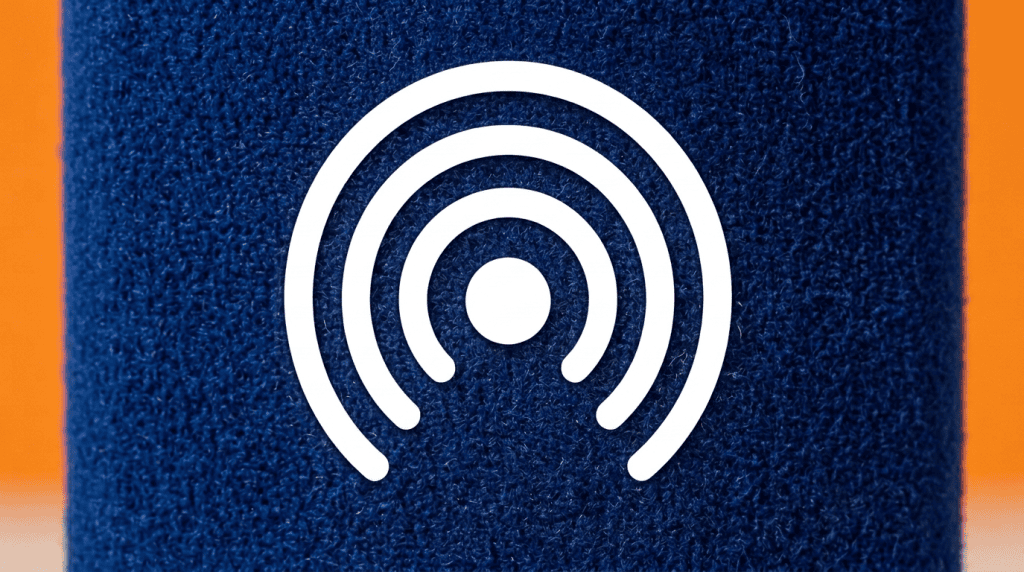Extreme close-up of a triangular three-sided flock-coated foam windshield face in deep blue with a raised white flock logo, velvety texture clearly visible, shallow depth of field