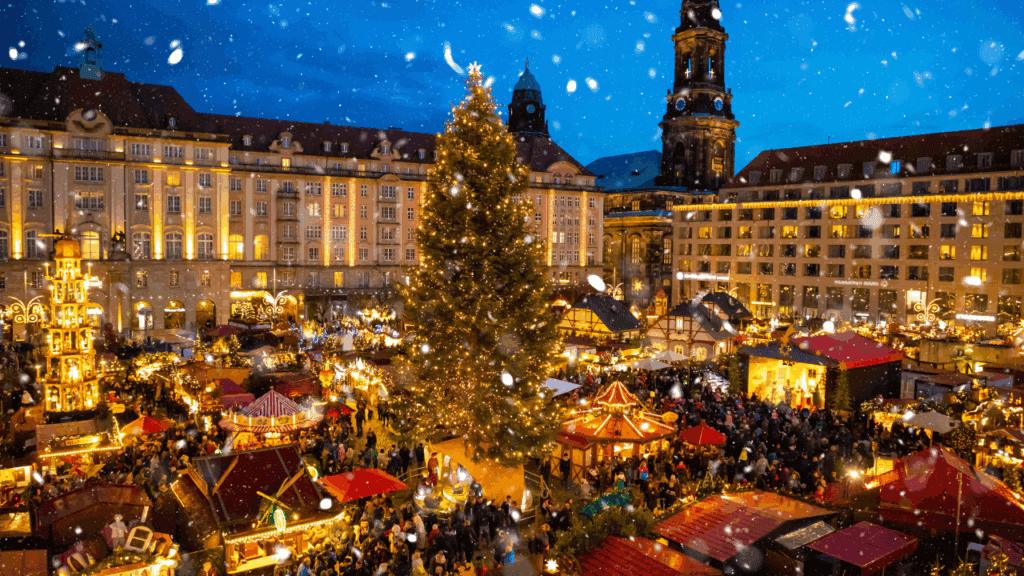 Festive Christmas market scene with decorated tree and holiday stalls at night in Strasbourg, France.