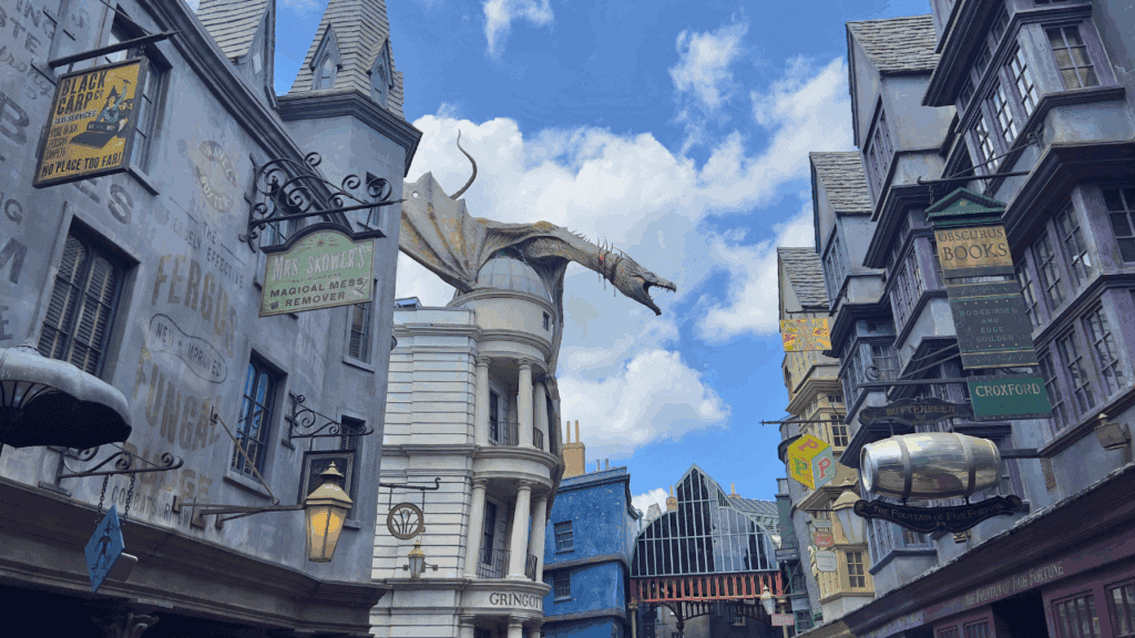 Dragon atop a whimsical cityscape with uniquely designed buildings and colorful signage.