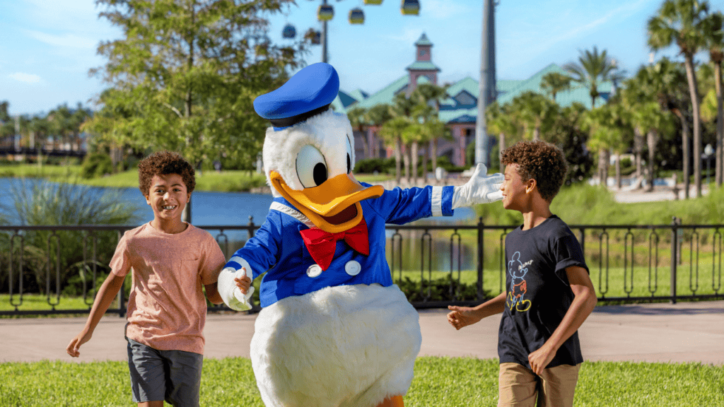 Kids with Donald Duck mascot at Disney World, enjoying summer vacation.