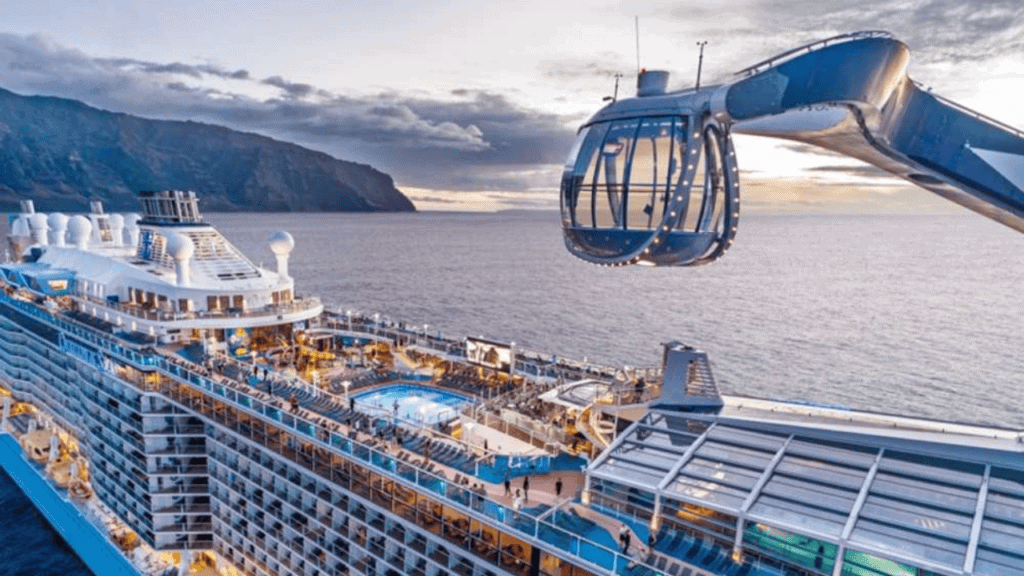 Cruise ship with helicopter on deck during sunset at sea.