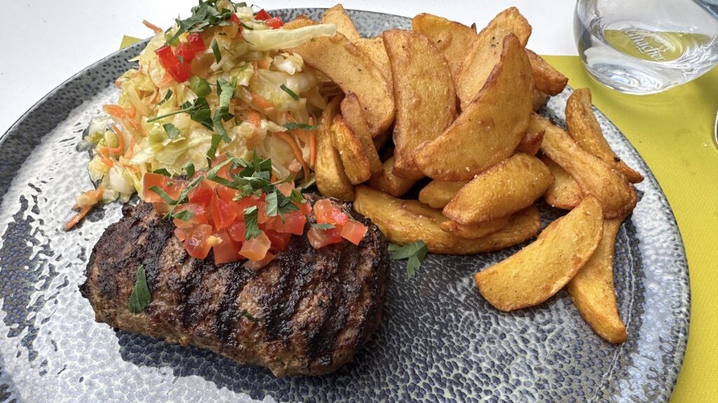 Bifteki mit Kartoffelspalten und Krautsalat