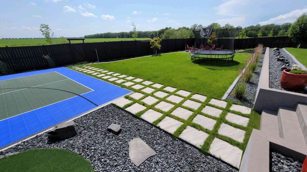 Backyard landscape with stone pathway, green lawn, and modern outdoor living design