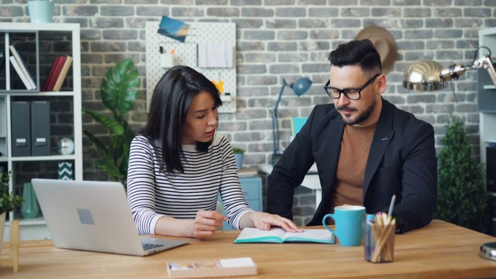 A Man and a Woman Discussing Some Paperwork