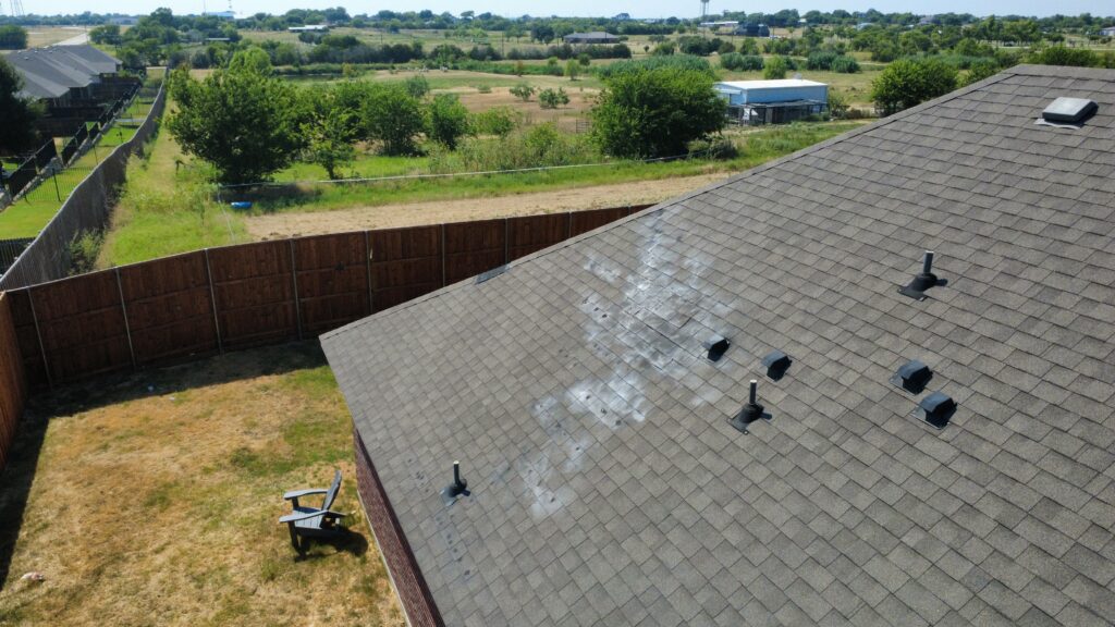 Close-up drone photo showing hail bruising and granule displacement on a roof facet, Krum, TX