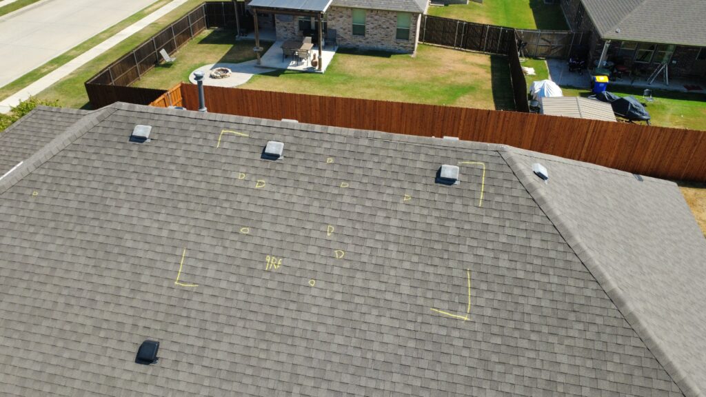 Asphalt shingle roof marked with yellow adjuster chalk, test squares and hail strike annotations during a DFW roof inspection
