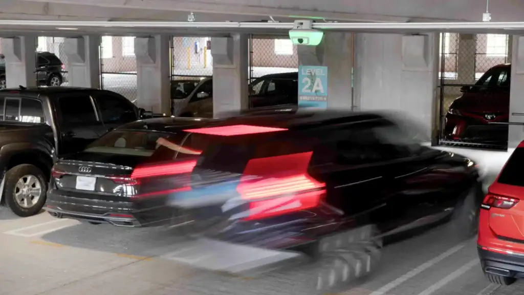 Car parking under green M5 sensor indicating open space in airport parking garage