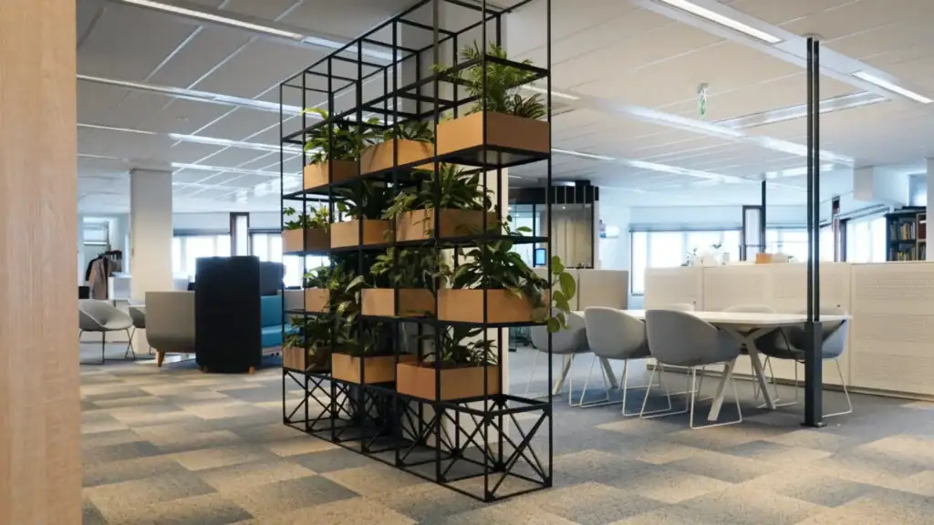 IPROTECT supporting modern open-plan office space with desks, chairs, and indoor plants