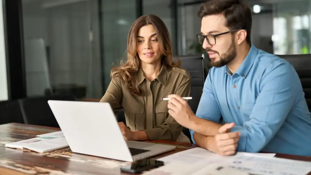 Two colleagues analysing surveillance data on a laptop using VDG SENSE Video Management System