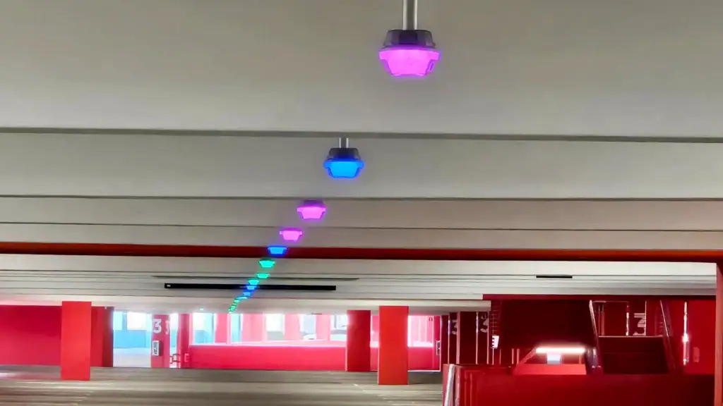 Modern parking garage at OCVIBE featuring an automated parking guidance system with multicolored M5 smart sensors above empty parking spaces