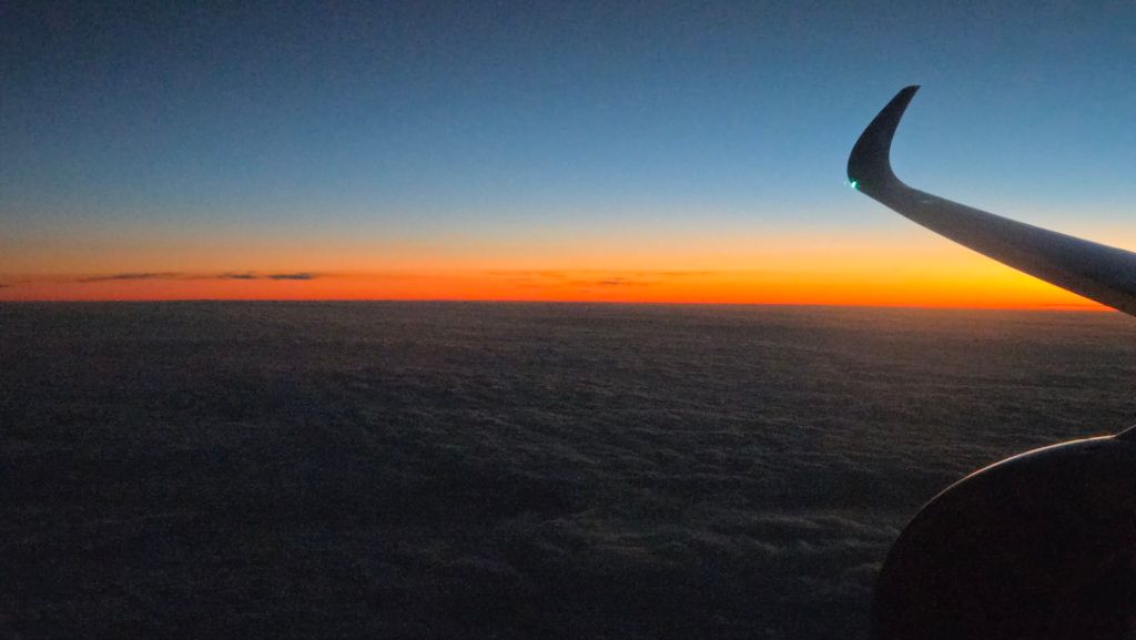 Sonnenuntergang über den Wolken aus dem Flugzeug