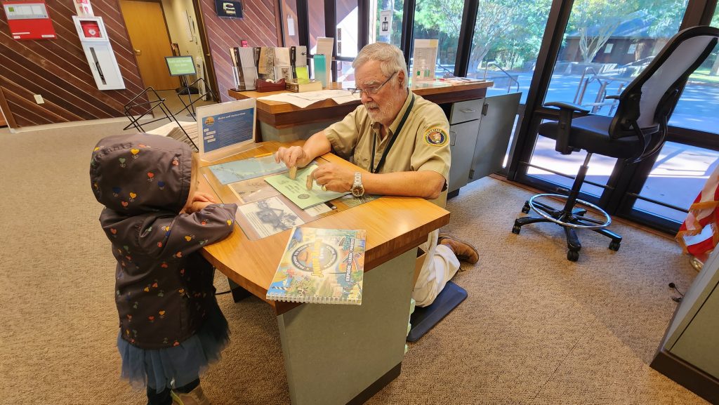 A little girl learning more about the history of the Fort Raleigh National Historic Site from a Park Ranger.