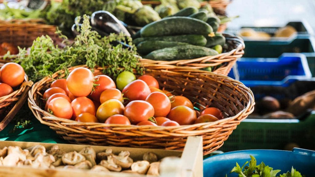 étal de marché provençal avec des légumes de saison dans des paniers