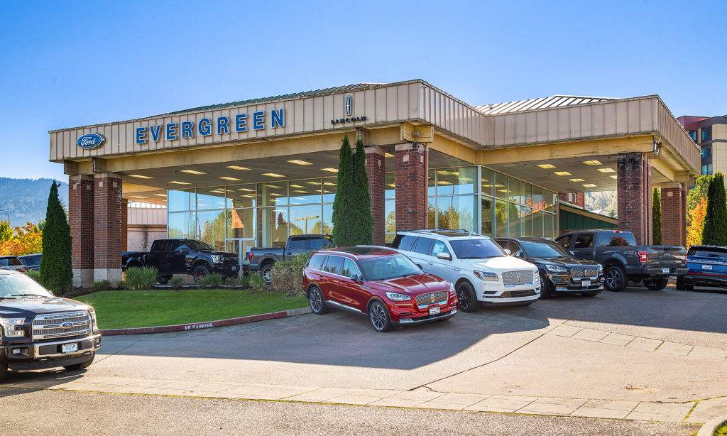 Storefront of 'Evergreen' dealership with Ford and Lincoln logos, cars on display in front