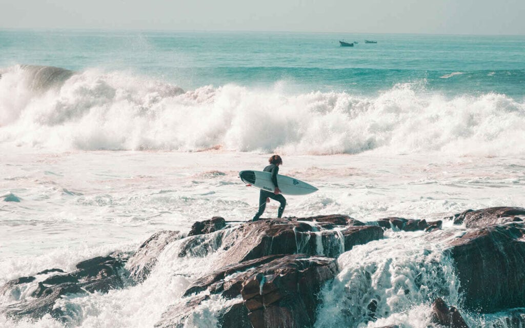 surfer with a shortboard in Anchor Point surf spot in Taghazout Bay surf village, Morocco