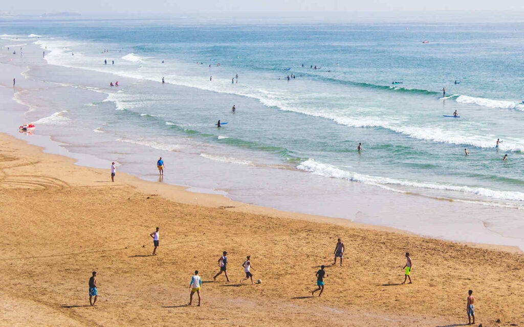 young guys playing football on a beach in southern morocco