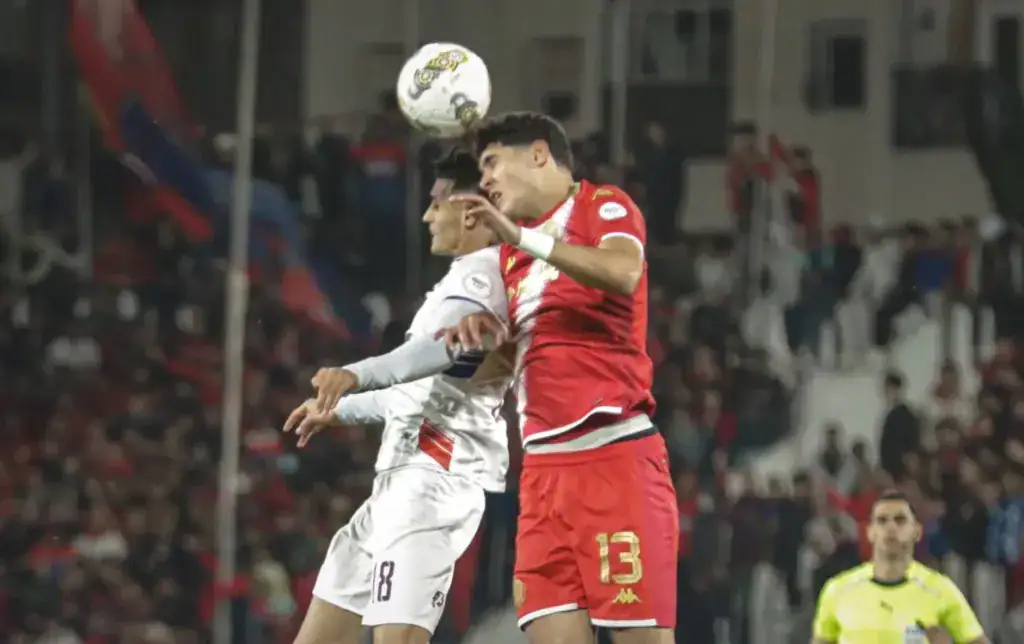 alt= duel aérien entre un joueur du WAC et un atre de l'OCS: