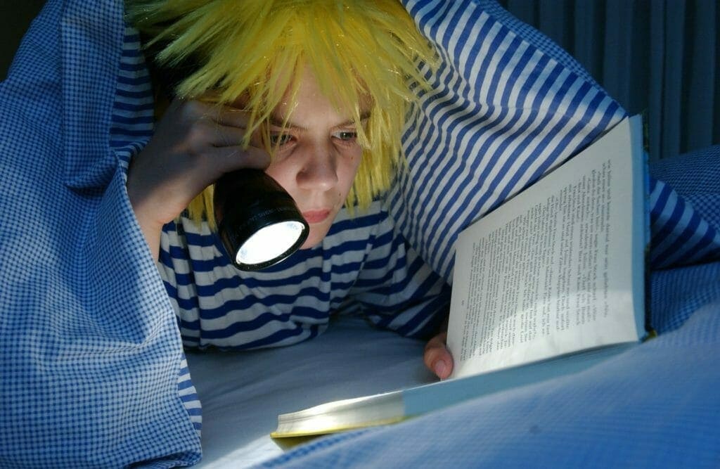夜更かしをして読書をする少年