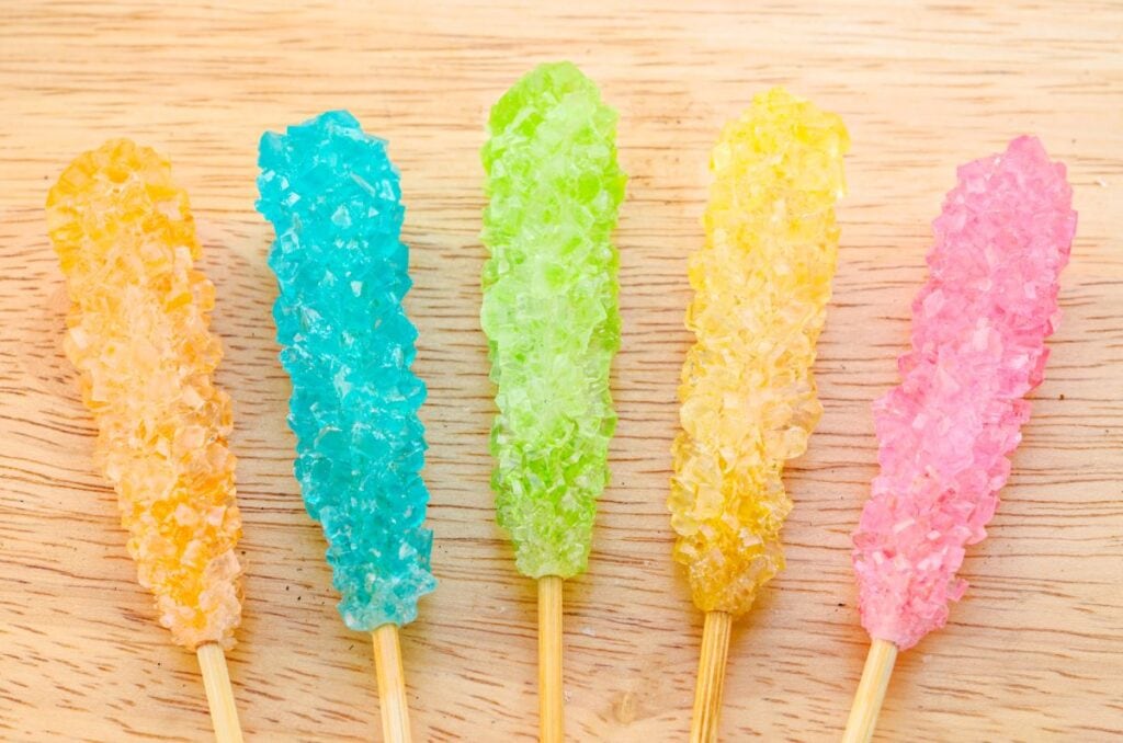 pastel colored rock candy sticks on wooden background