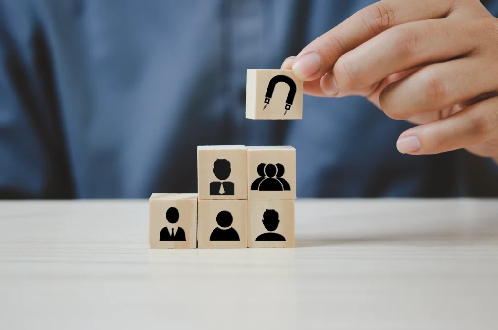 A person displays wooden blocks with figures of people on them, representing different cultures and backgrounds.