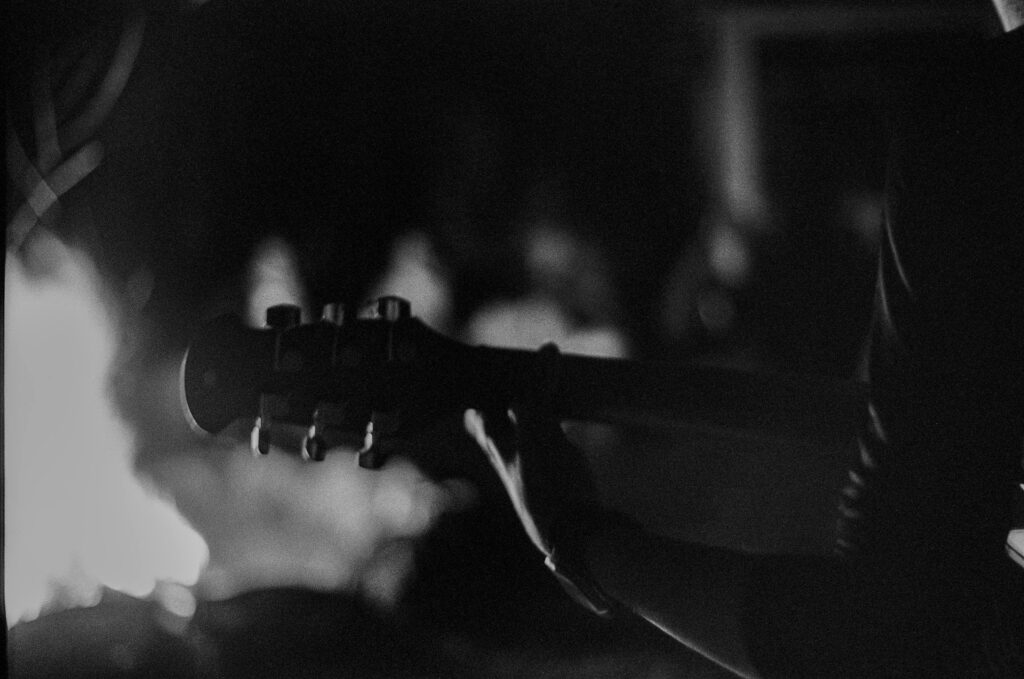 Stories & worship Artistic monochrome image of a person playing guitar at night, capturing a moody ambiance.