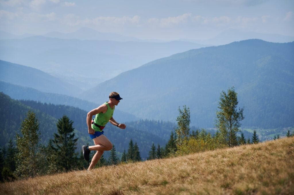 atleta di trail running che corre in salita
