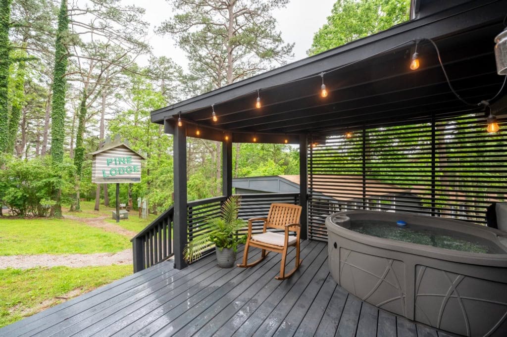 Relaxing outdoor hot tub and cozy seating on a cabin porch in Eureka Springs, Arkansas.