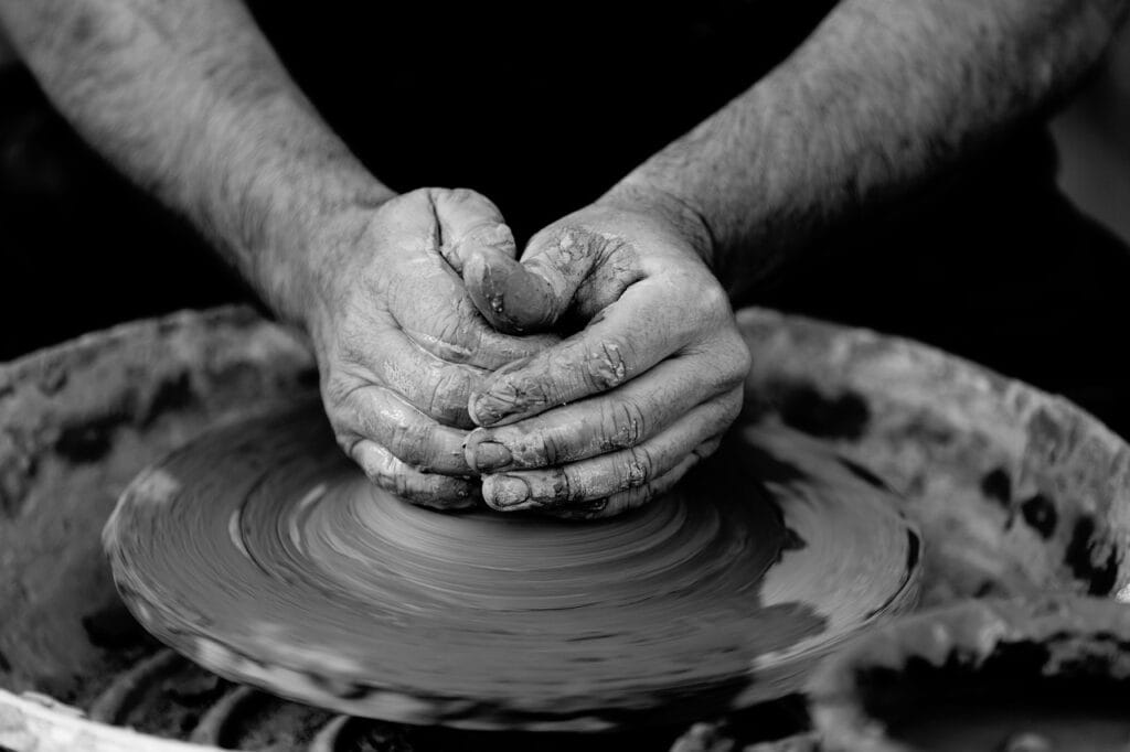 hands on a pottery wheel throwing clay