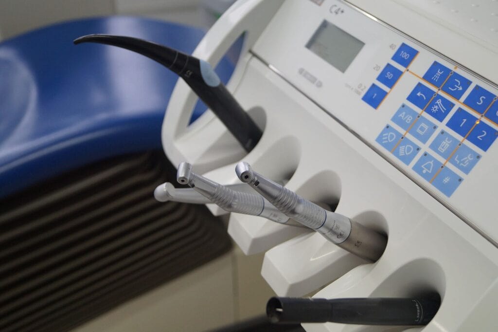 Close-up of dental delivery system with high-speed handpieces and ultrasonic scaler tips in holder