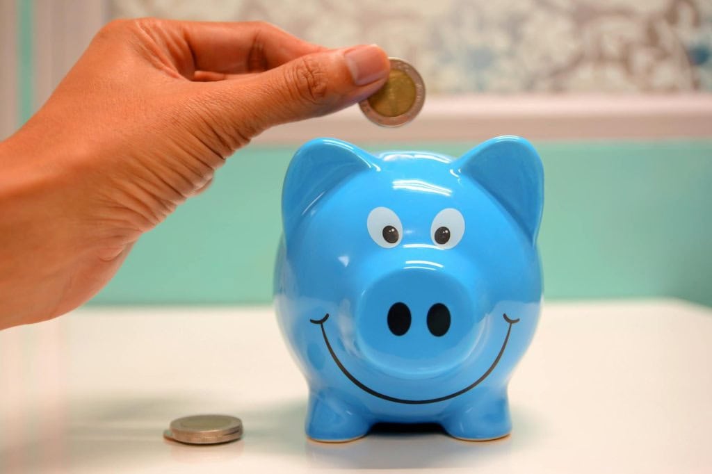 Putting coins into a piggy bank