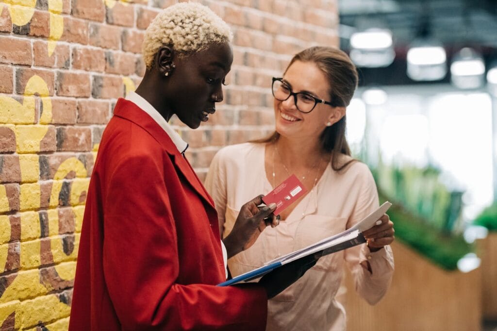 Two Women Talking with a Credit Card and Some Paperwork