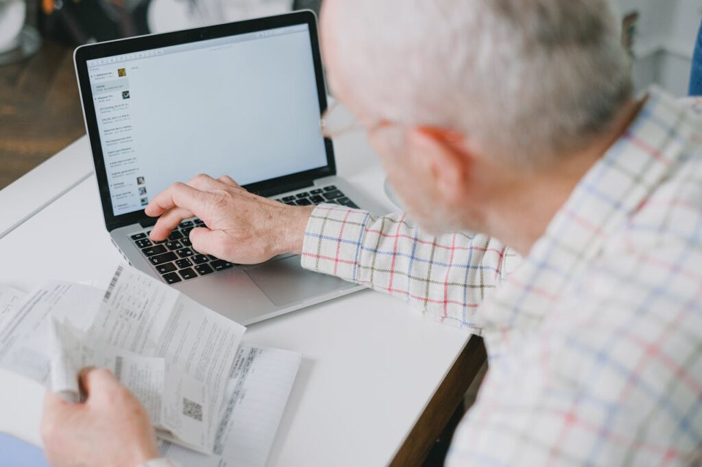 A Man Using a Laptop While Holding some Bills
