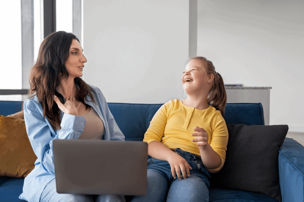 Support coordinator sitting with a young girl on sofa