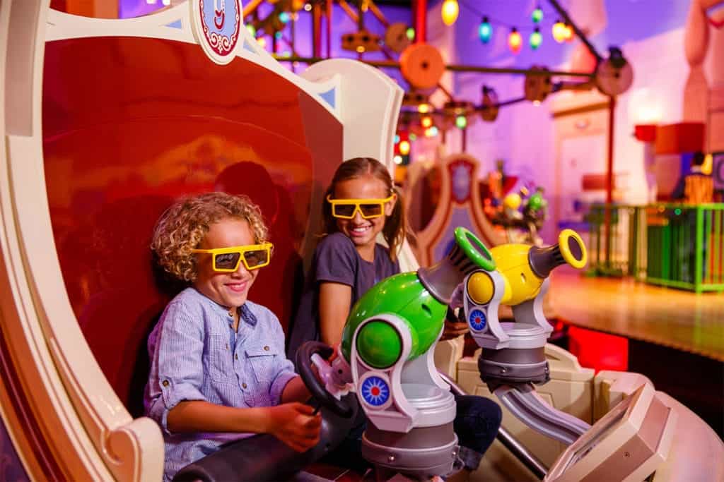 Bright children enjoying a fun themed ride at an indoor amusement park.