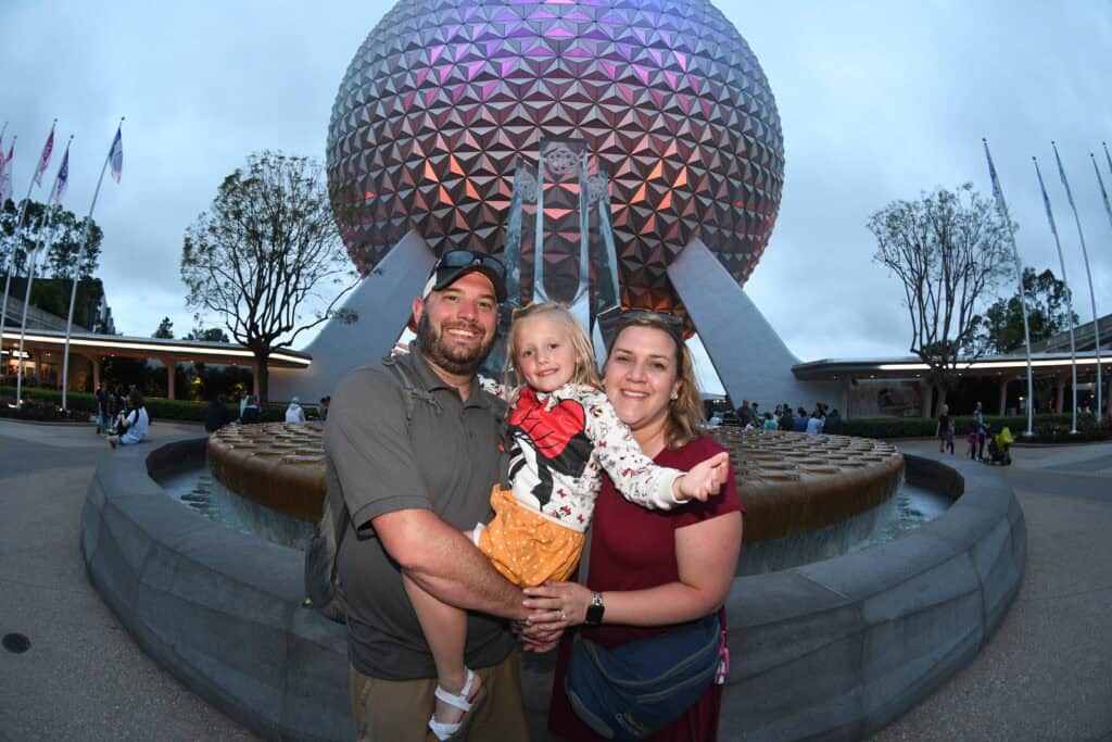Family enjoying a family vacation in front of Spaceship Earth at EPCOT, Walt Disney World.