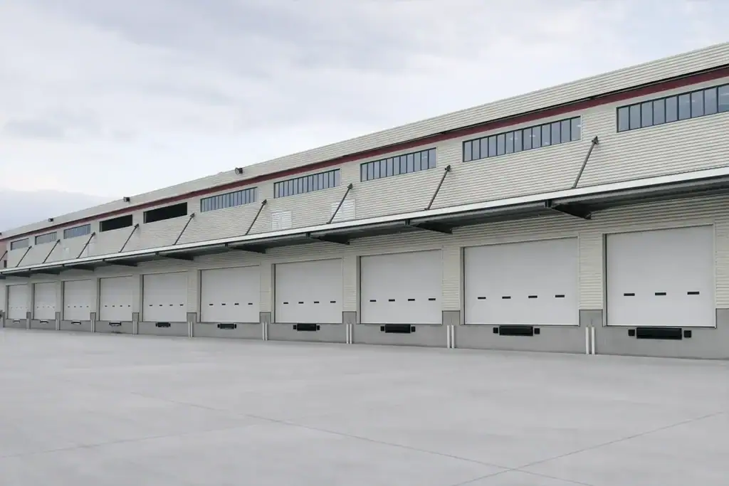 A row of high-performance industrial sectional doors installed at a large-scale logistics hub, showcasing ABX's custom-sized and CE-certified access solutions.
