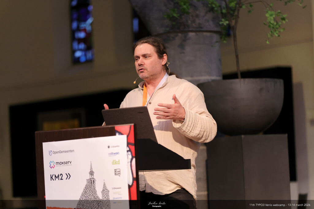 Marc enthusiastically gesturing during a talk in a former church